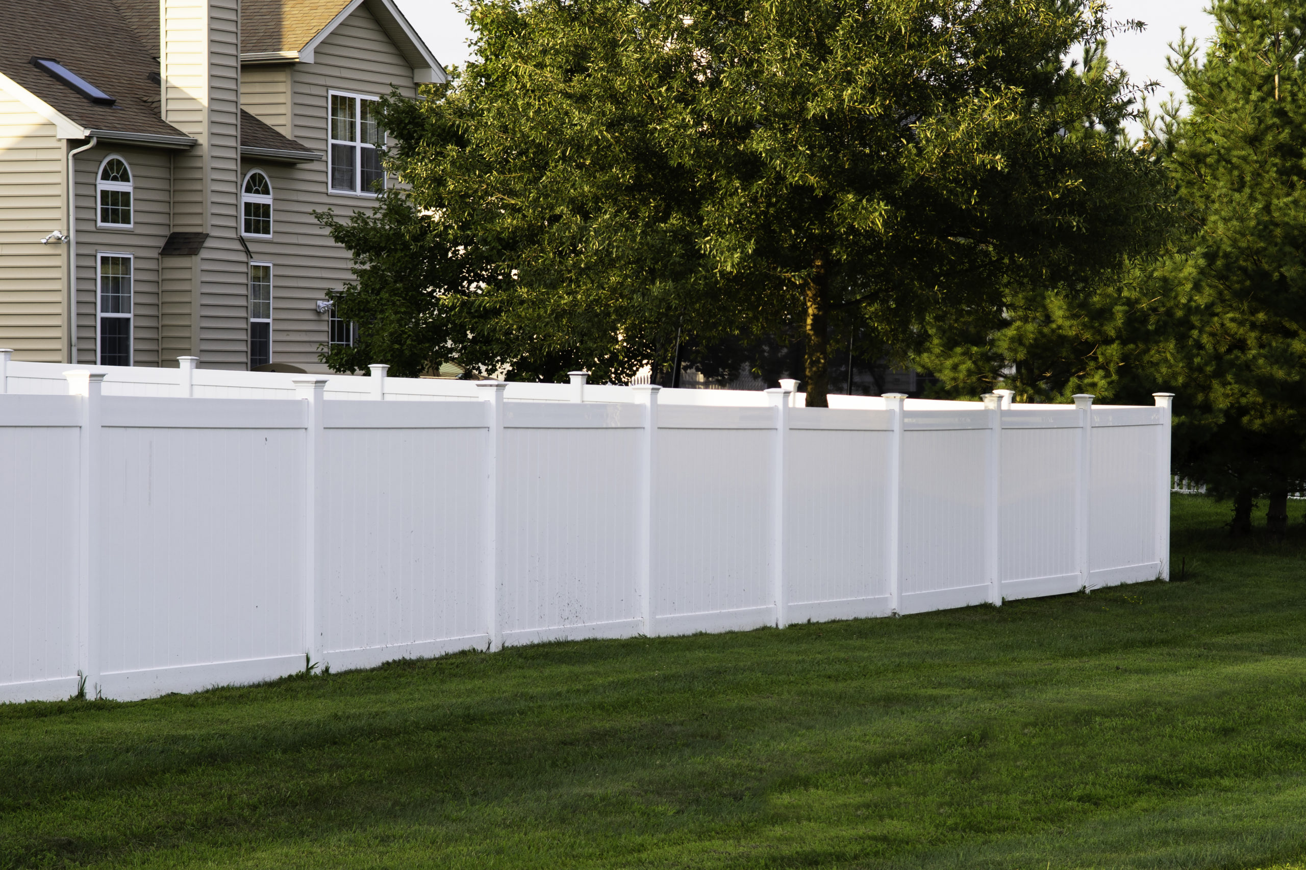 Tall white vinyl fence in a home’s yard