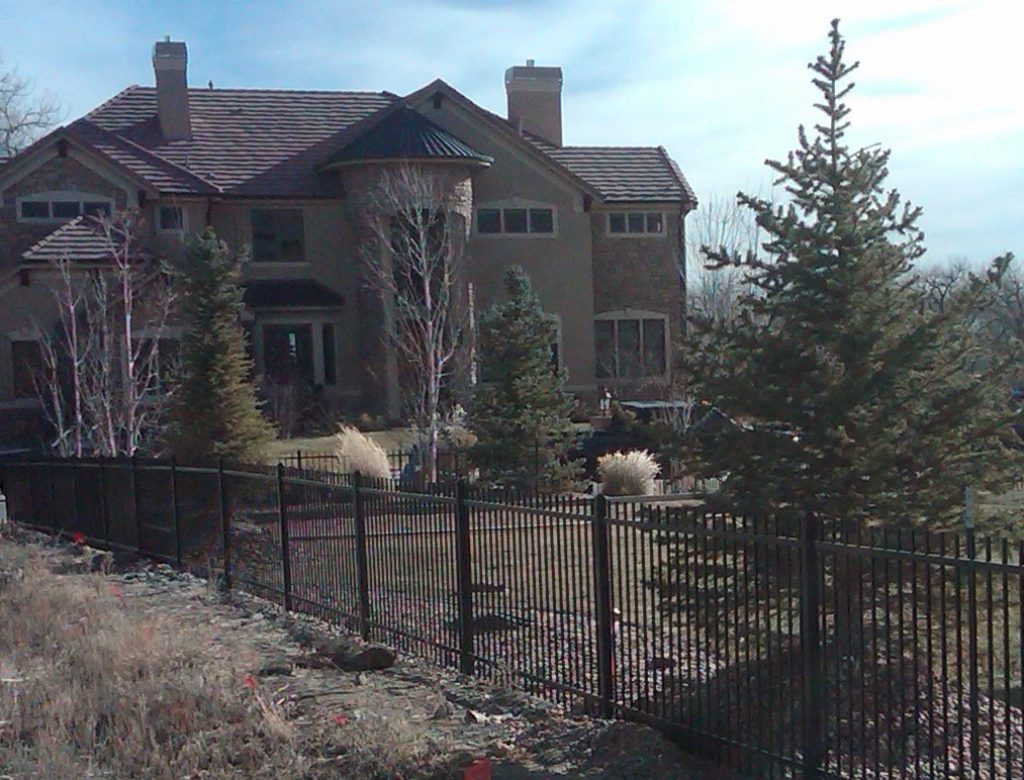 a wrought iron fence surrounding a huge yard in front of a big house in Denver, Colorado